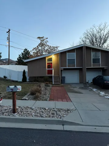Split-level residence featuring a prominent red entry door and an angled roofline