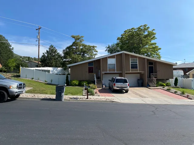 Split-level duplex featuring brown siding and white trim