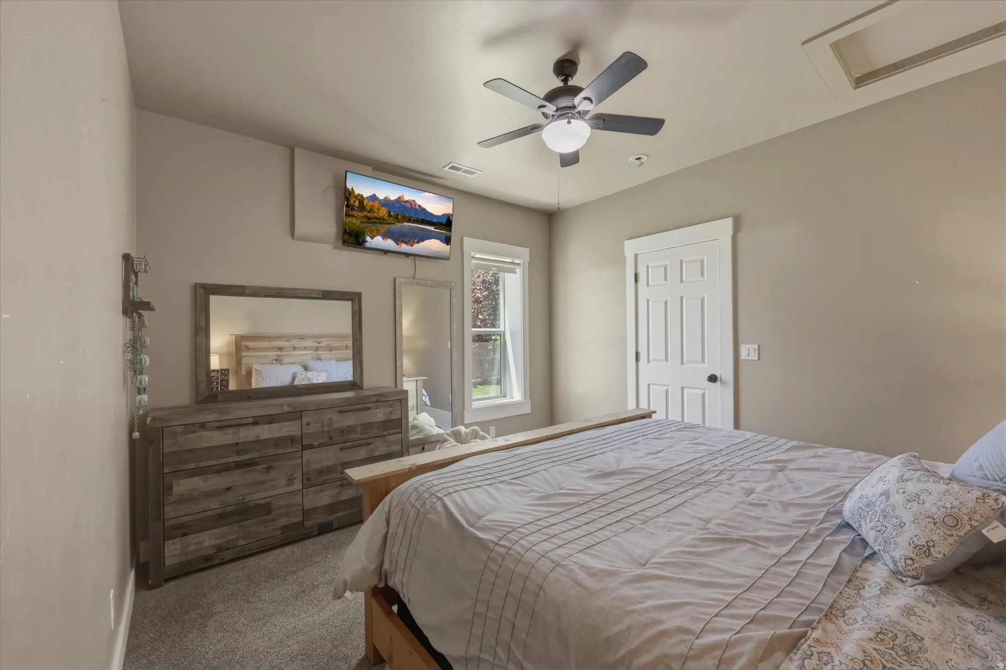 Bedroom 1    Neutral-toned bedroom featuring carpet flooring and a ceiling fan with integrated lighting