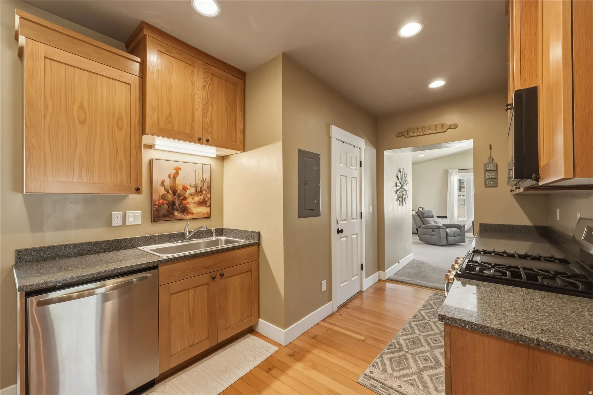 Kitchen featuring wood cabinetry, stainless steel dishwasher, and a stainless steel sink