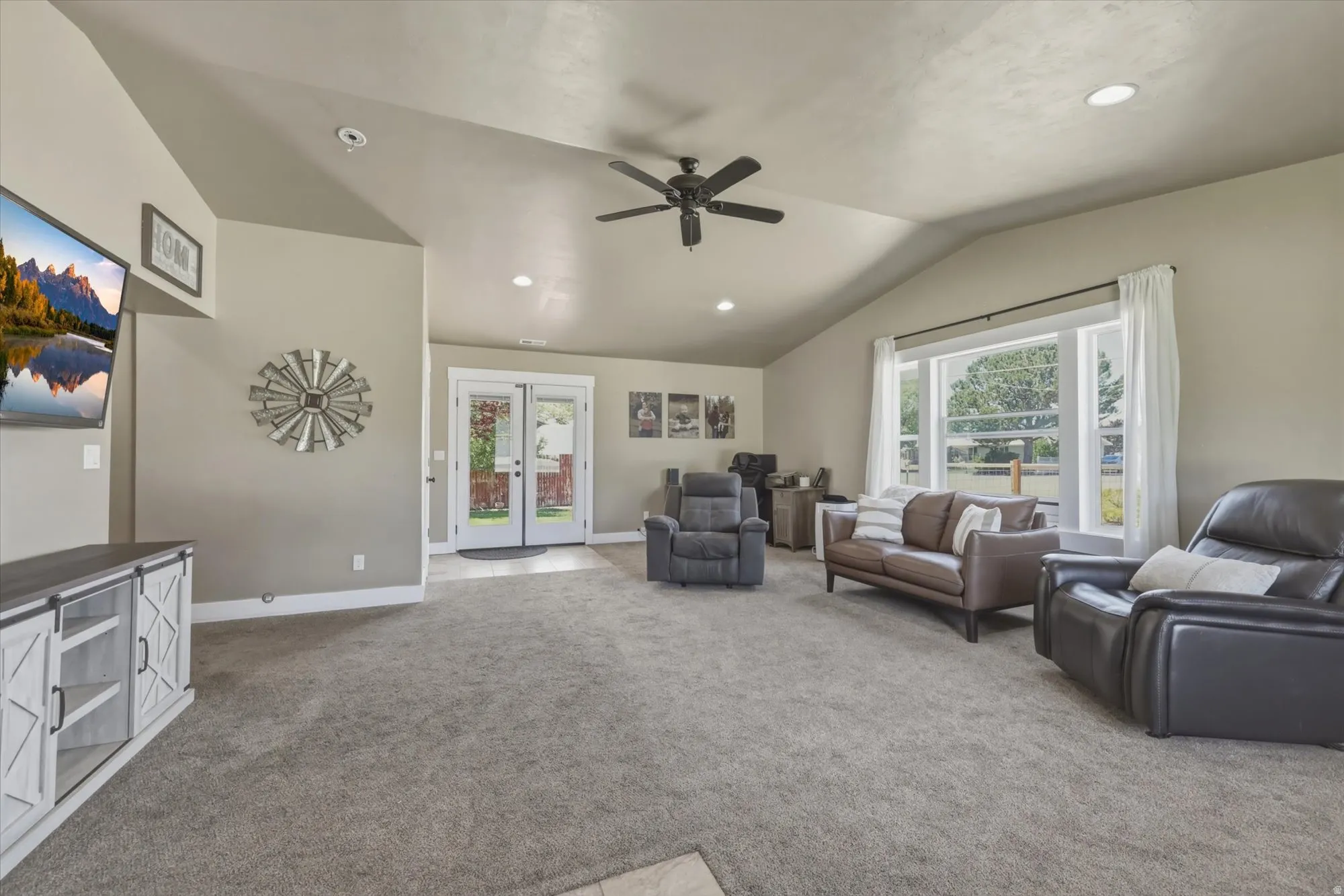Spacious living area featuring vaulted ceilings, recessed lighting, and a ceiling fan