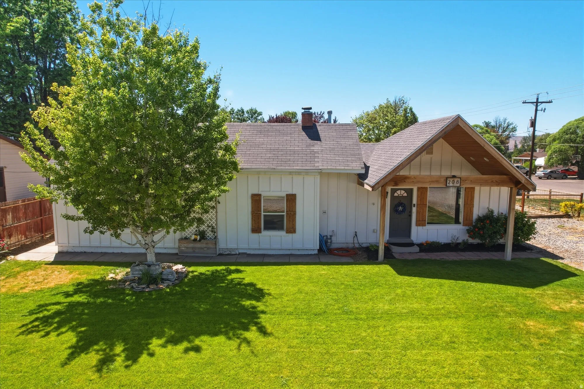 White siding exterior with a dark shingle roof and a covered entryway