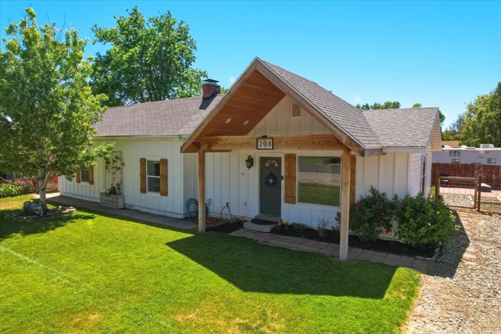 White board-and-batten exterior with contrasting wood shutters and a dark front door
