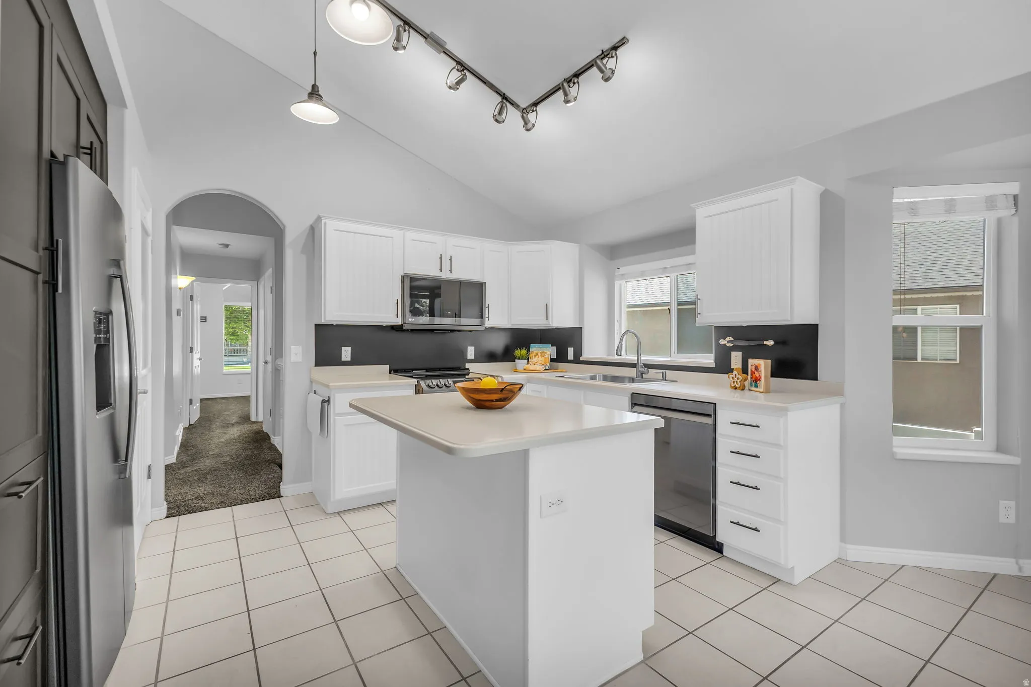 Contemporary kitchen featuring a vaulted ceiling and track lighting