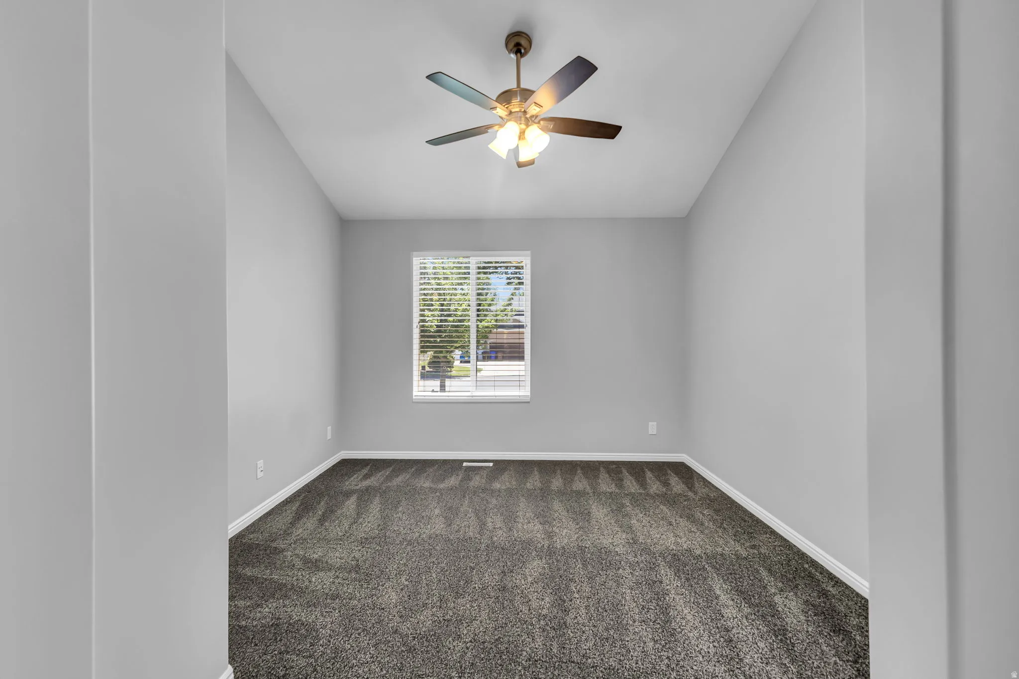 Room featuring textured carpeting, white baseboards, and neutral wall paint