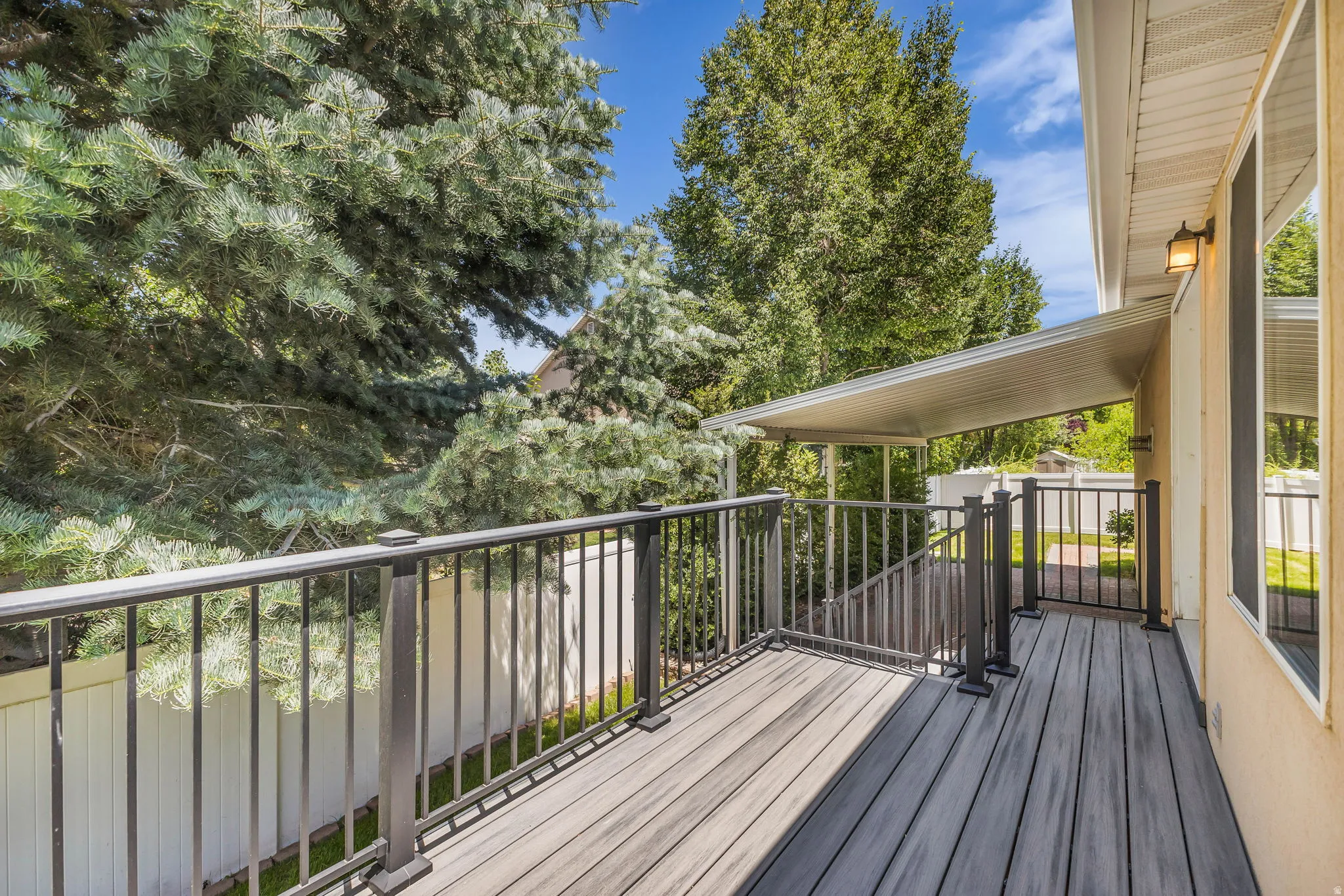 Expansive outdoor deck featuring wood-finish composite decking and dark metal railings