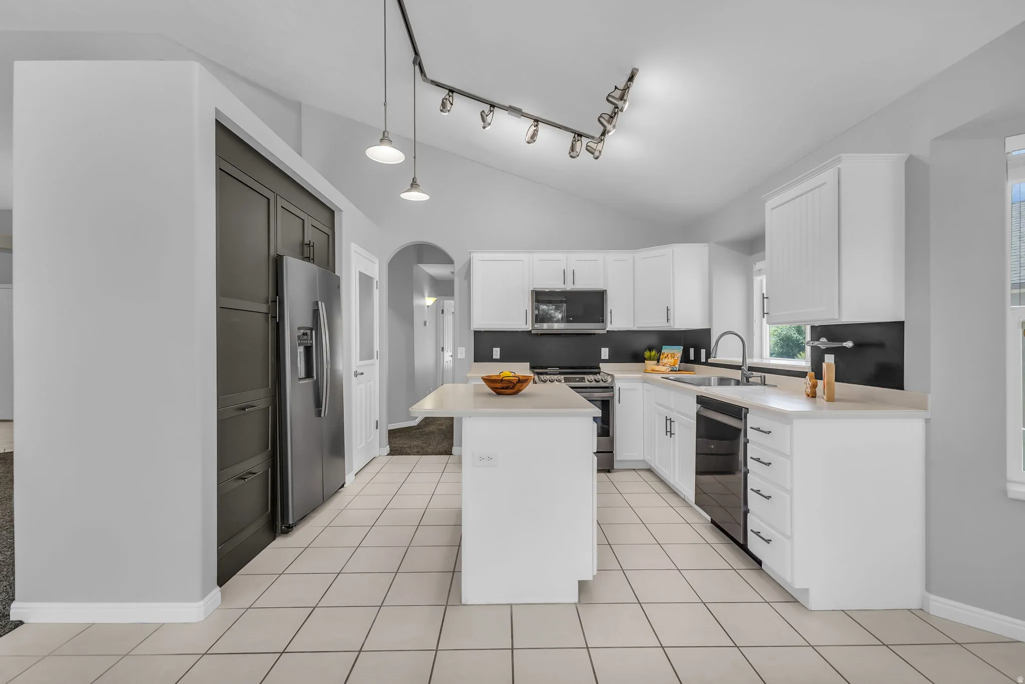 Kitchen featuring white cabinetry, light countertops, and stainless steel appliances