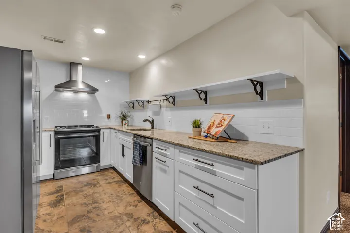 Kitchen featuring white cabinetry, granite countertops, stainless steel appliances, a white subway tile backsplash, and recessed lighting