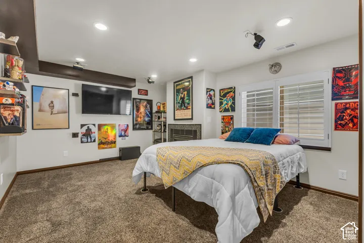 Carpeted room featuring recessed lighting and a mounted television