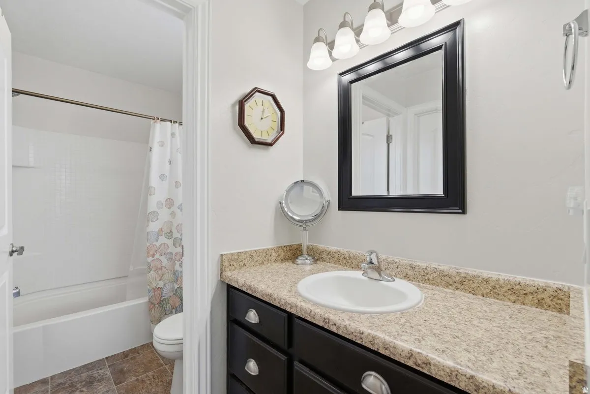 Bathroom featuring a vanity with dark cabinetry and a light-colored countertop