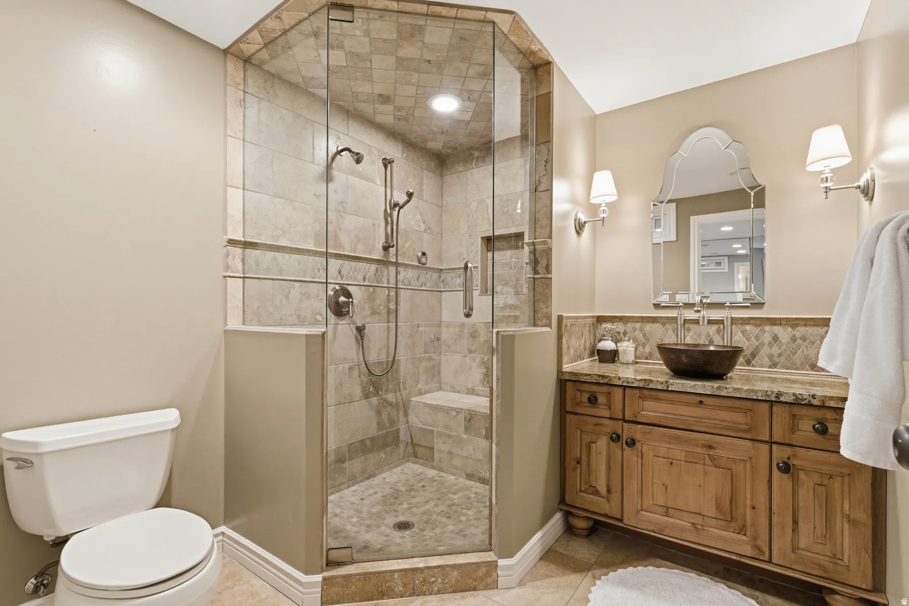 Glass-enclosed shower with tile surround and built-in bench