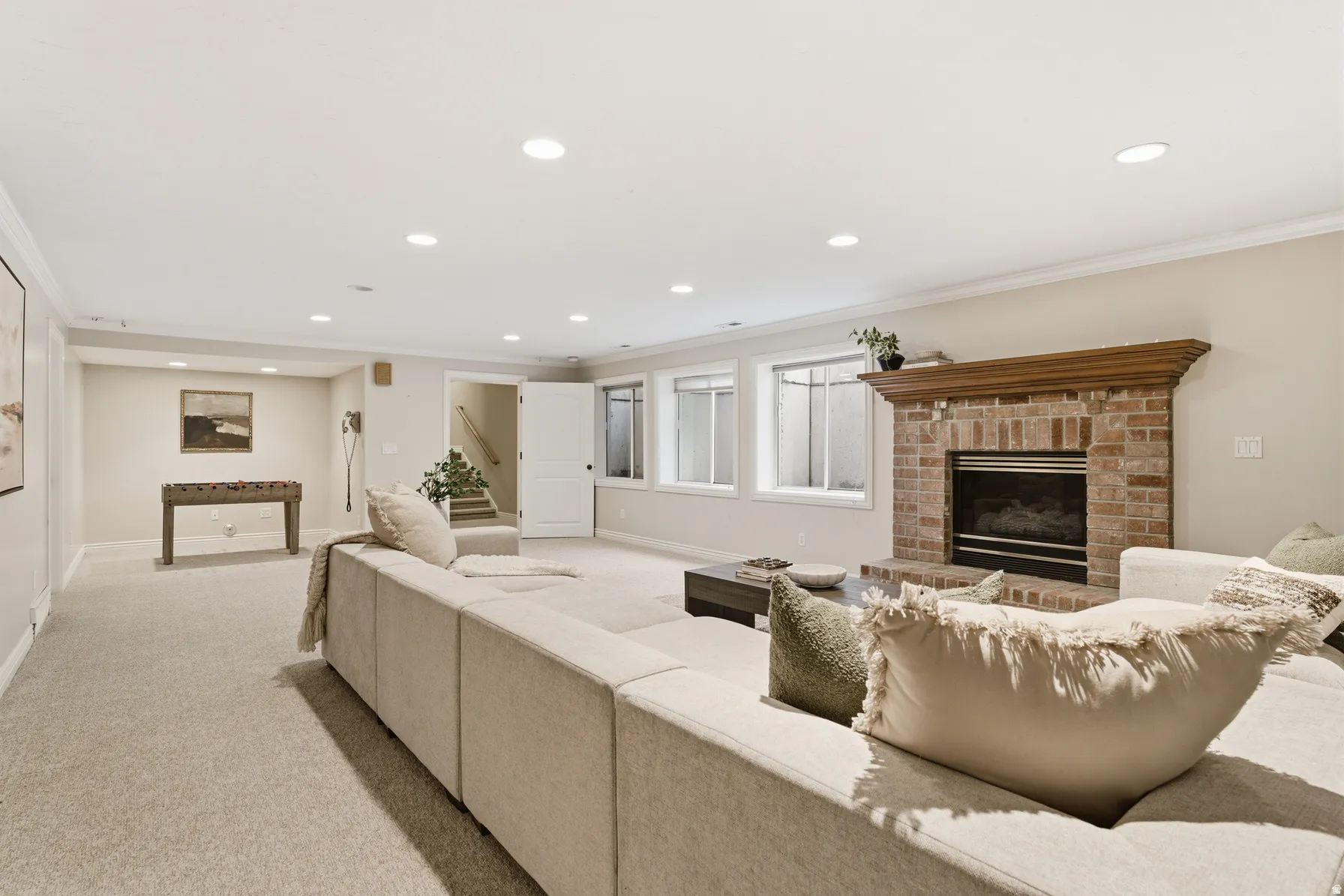 Spacious recreation room featuring light-colored carpeting and recessed lighting
