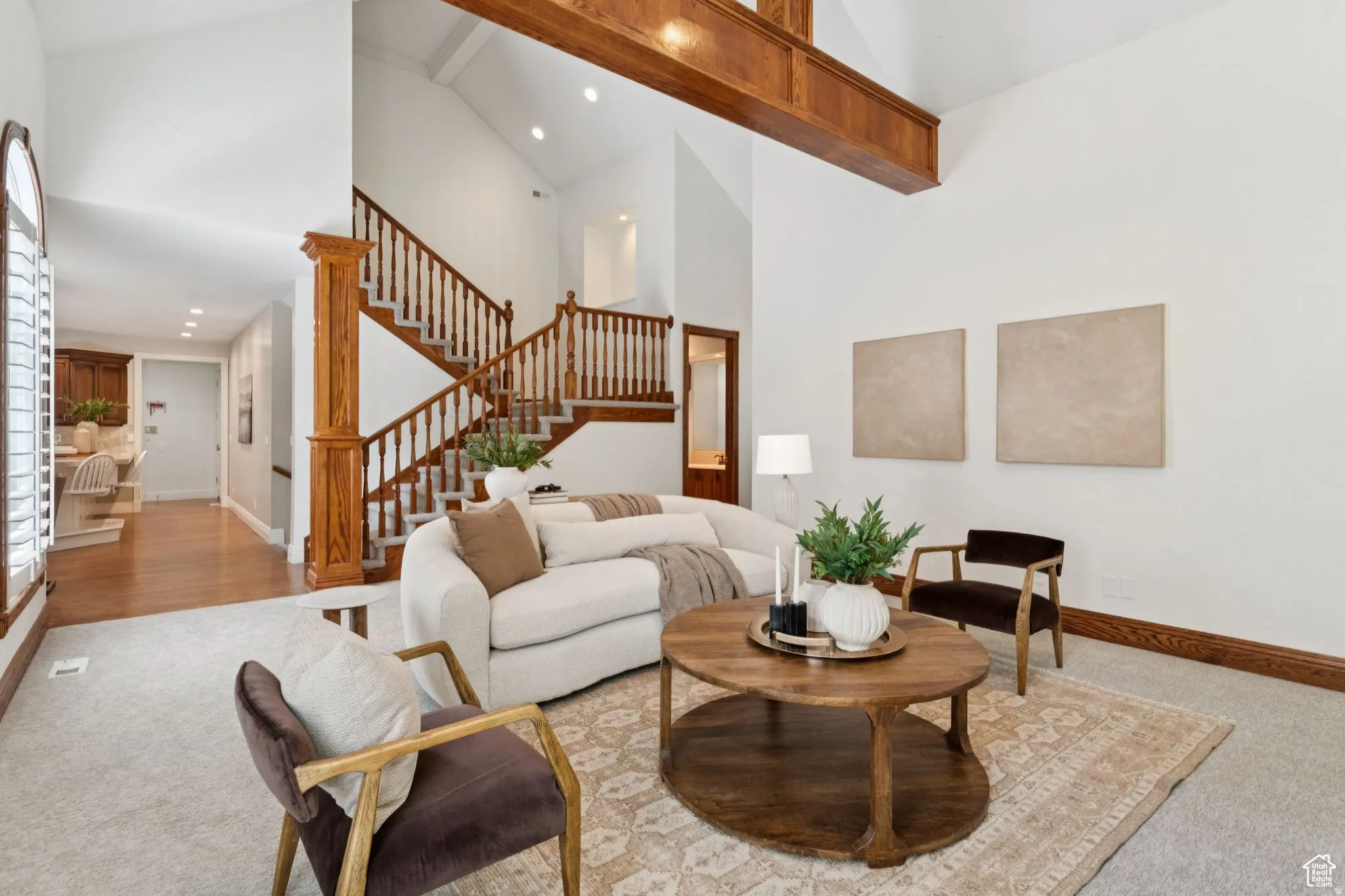 Spacious living area featuring a vaulted ceiling with exposed wood beams