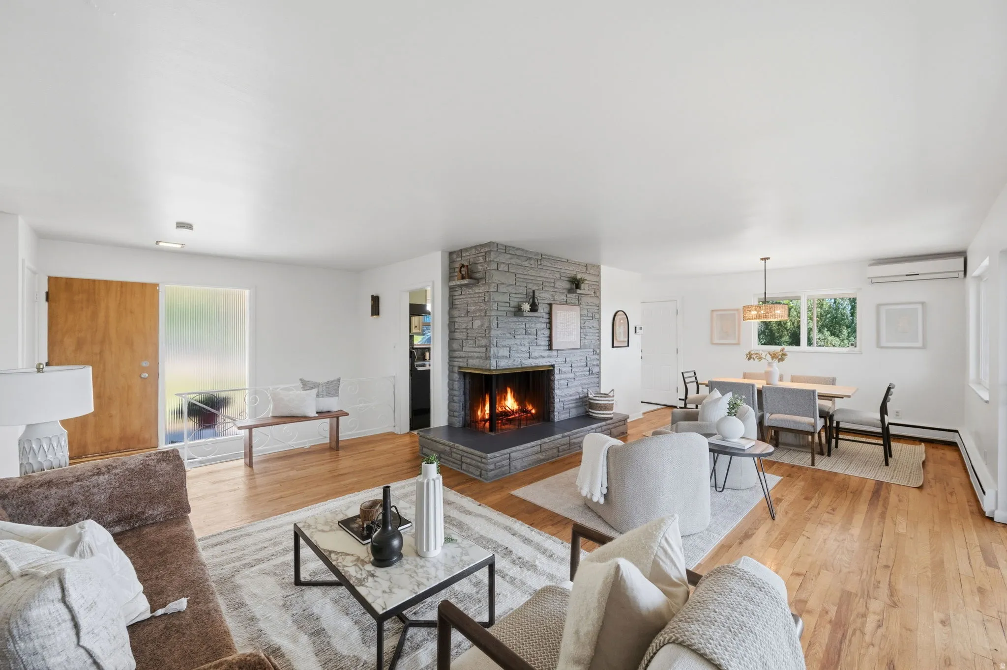Spacious interior featuring wood-finish flooring and a stone-clad fireplace