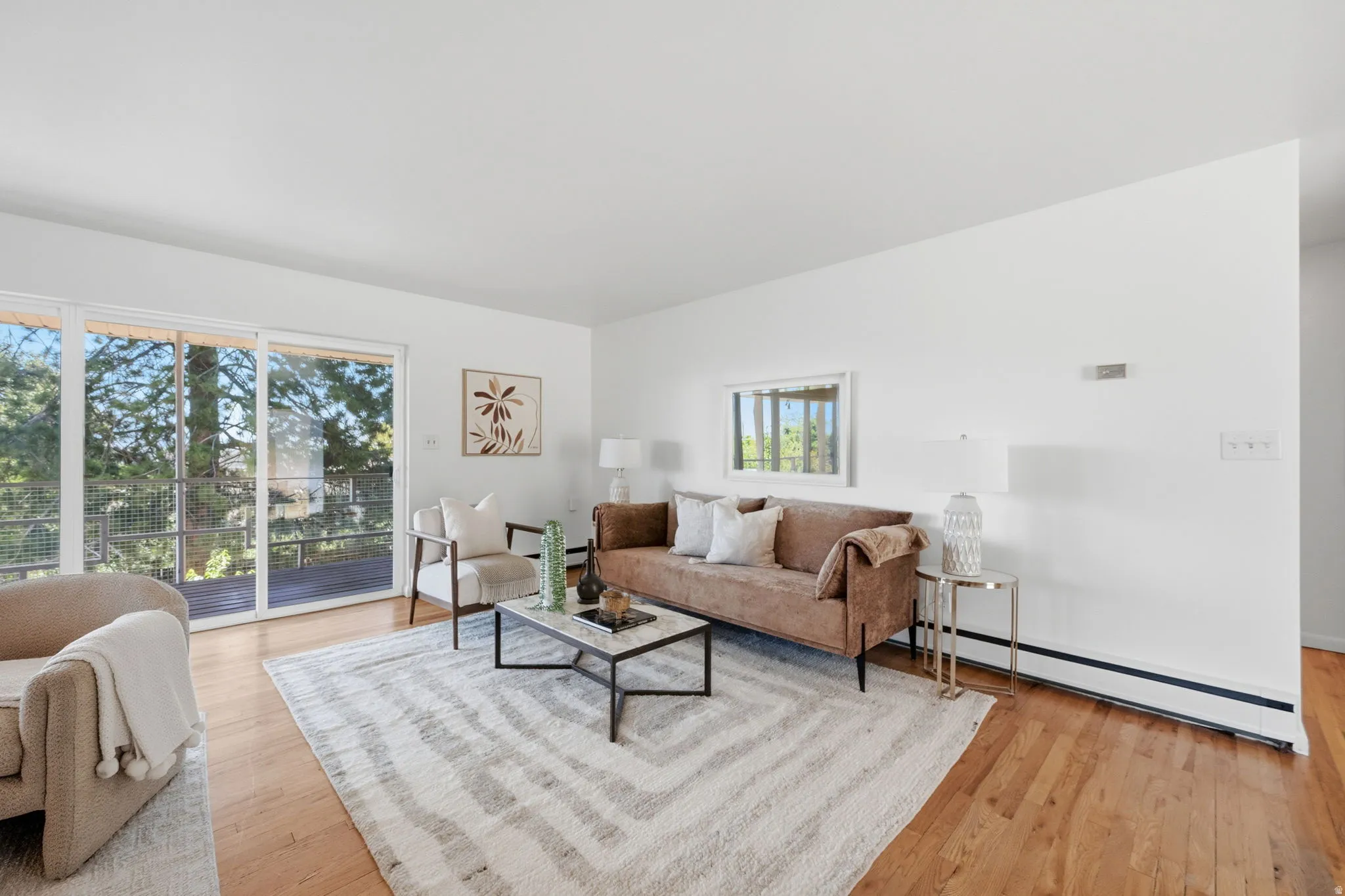 Spacious living area featuring wood-finish flooring and white walls