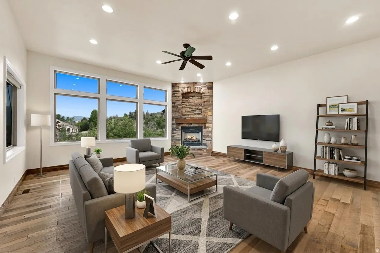 Spacious living area featuring large picture windows, wood-finish flooring, and recessed ceiling lights