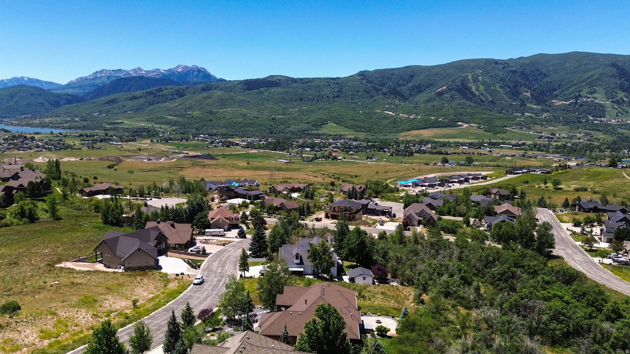 Expansive landscape featuring a valley, distant mountains, and a body of water