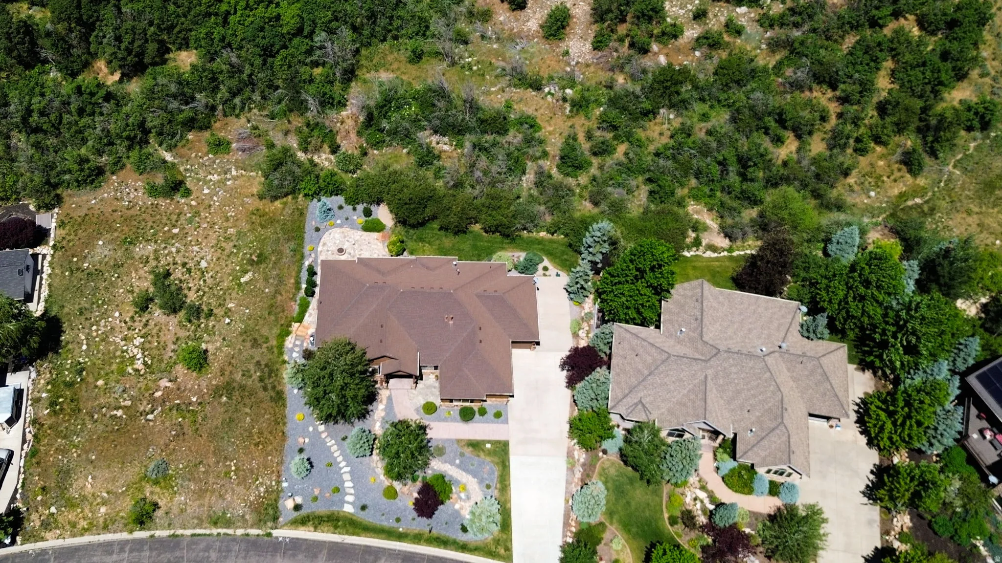 Expansive lot featuring a property with a multi-gabled roof and a paved driveway