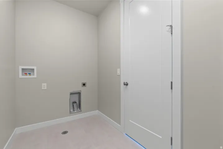 Dedicated laundry area featuring light gray wall paint, white baseboards, and light-toned tile flooring