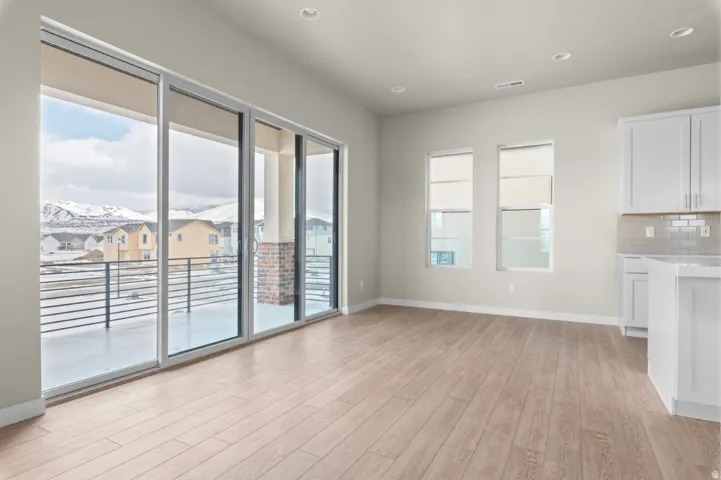 Spacious interior featuring wide plank wood-finish flooring, recessed lighting, and a neutral color palette