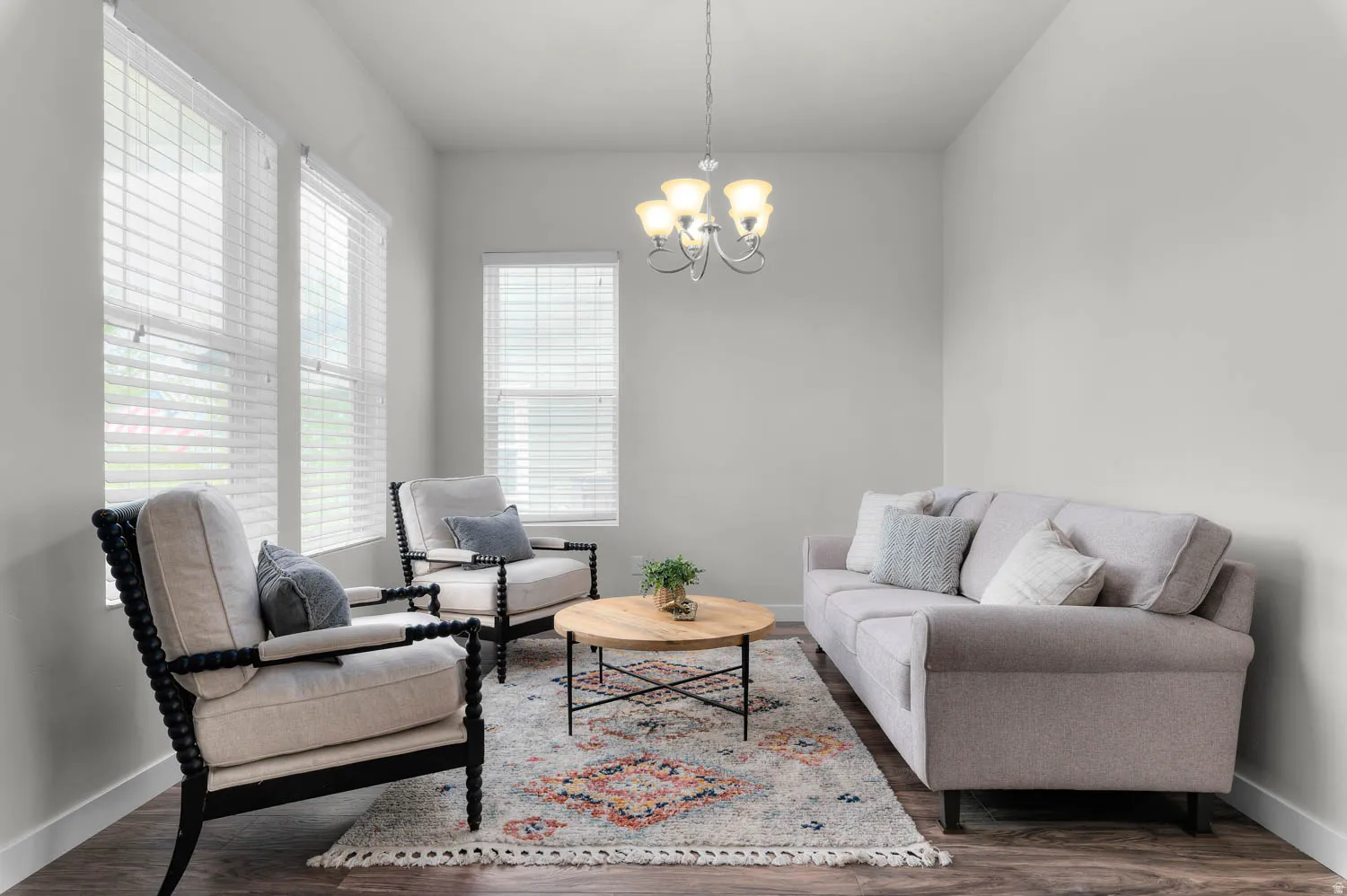 Living area featuring wood-finish flooring, light grey wall paint, and multiple windows with white blinds