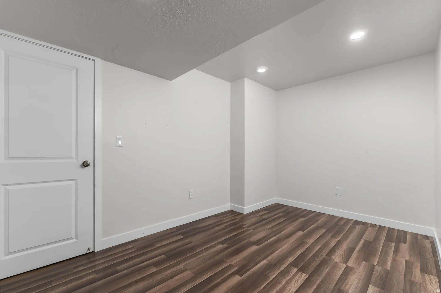 Room featuring wood-finish flooring, white baseboards, and neutral wall paint