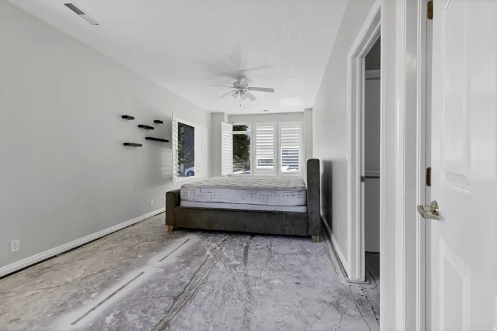 Bedroom featuring light gray wall paint and concrete subfloor