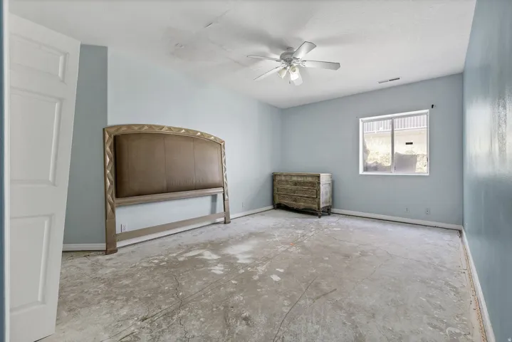Room featuring light blue walls, a white ceiling fan, and a window with white blinds