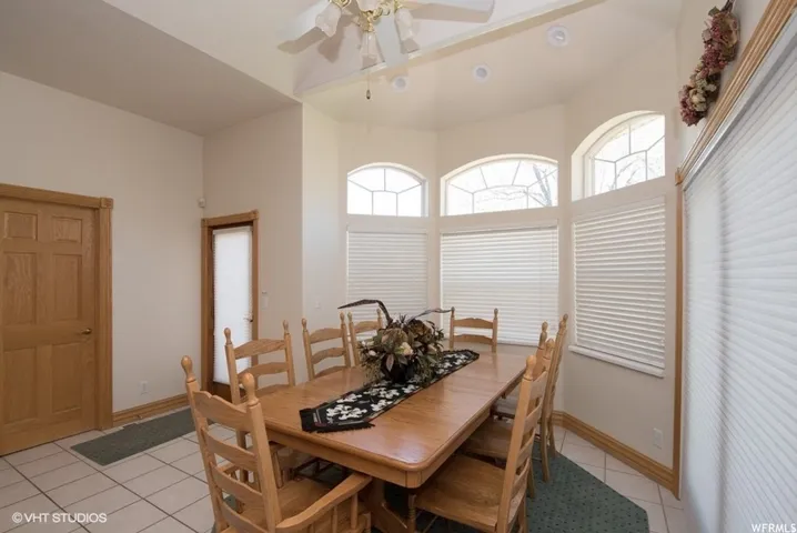 Dining space featuring a bay window with arched transom elements, recessed lighting, and tile flooring