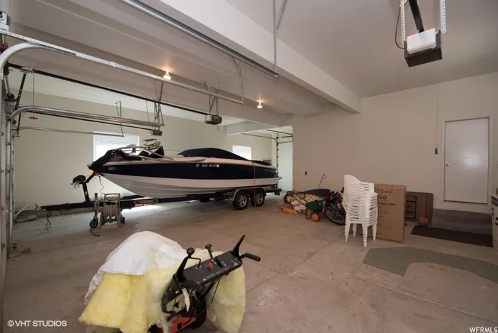 Spacious garage featuring concrete flooring and two overhead garage doors