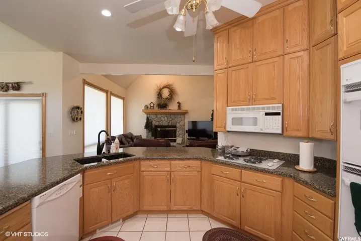 U-shaped kitchen counter with an integrated sink, built-in dishwasher, and cooktop