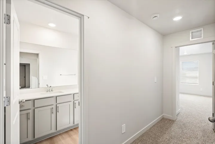 **DISLCAIMER** Interior package may vary. Bathroom vanity featuring light-toned cabinetry, a built-in sink, and a rectangular mirror