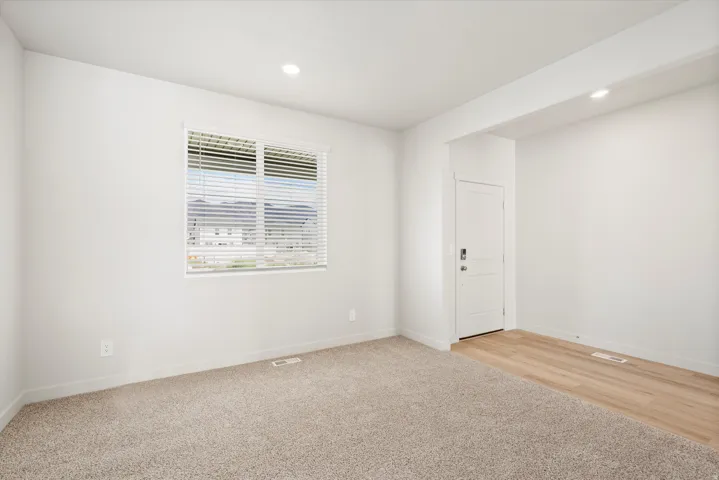 **DISLCAIMER** Interior package may vary. Bright room with recessed lighting, a window with horizontal blinds, and a combination of light-colored carpeting and wood-finish flooring