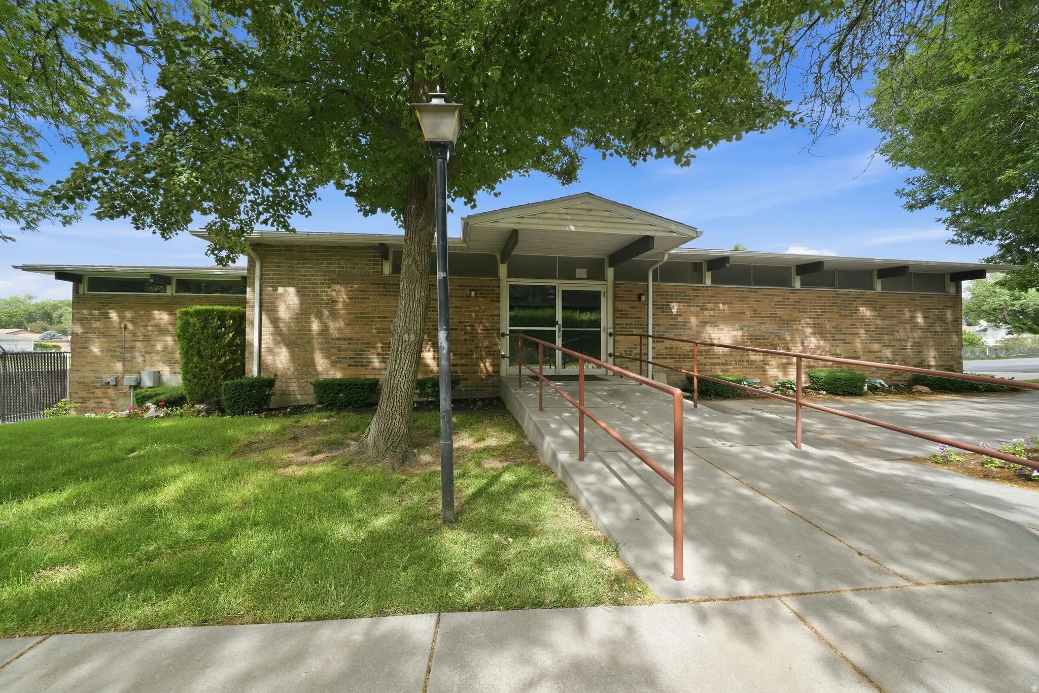 Club House Exterior mid-century modern architecture featuring a brick facade, transom windows, and a covered entrance