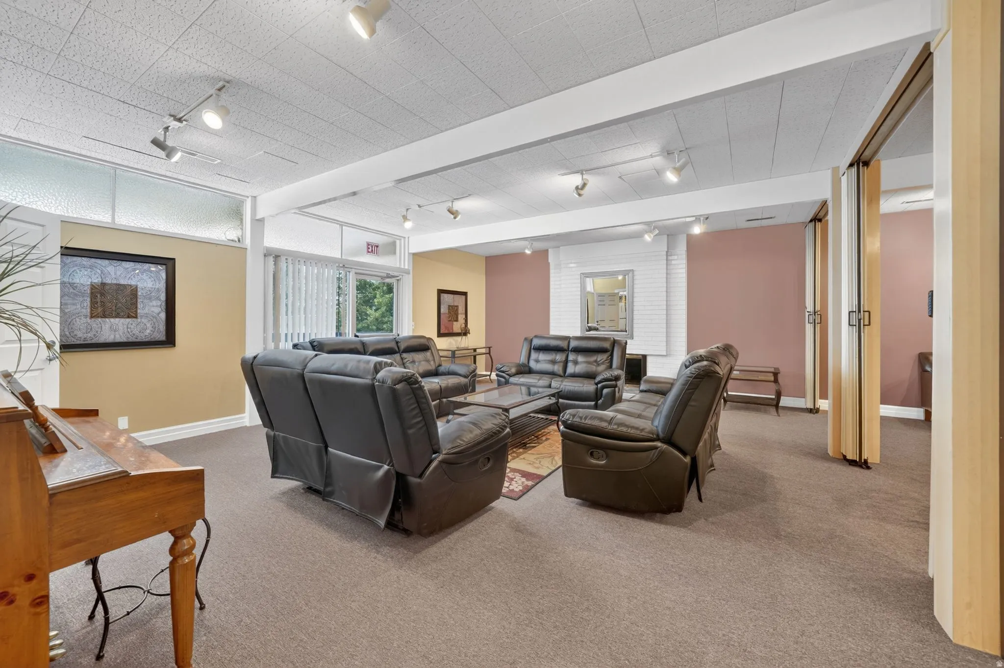 Club house spacious common area featuring track lighting, light-colored carpeting, and a white drop ceiling