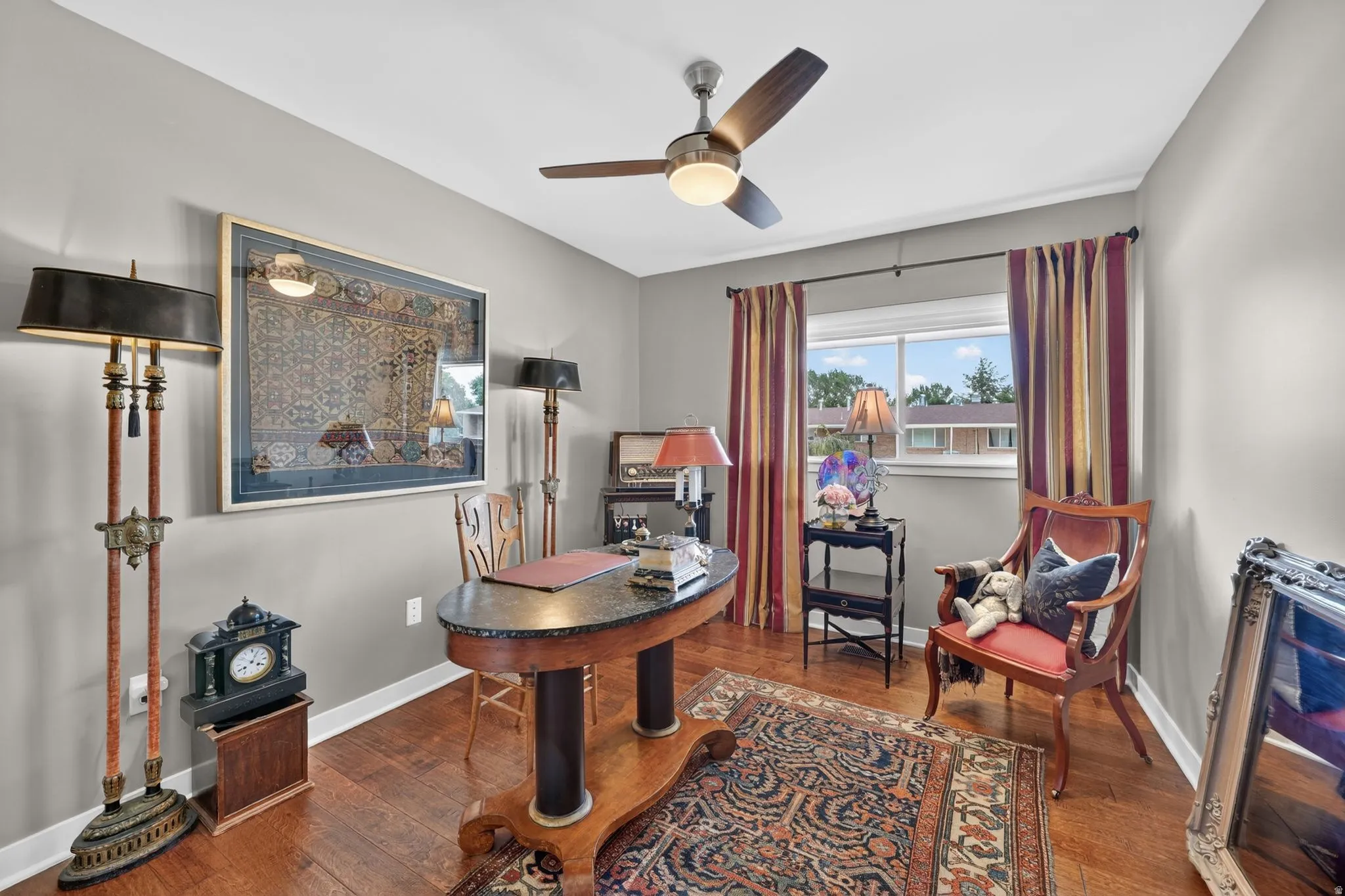 Bedroom/ office featuring a ceiling fan with integrated lighting, window with natural light, and neutral wall paint