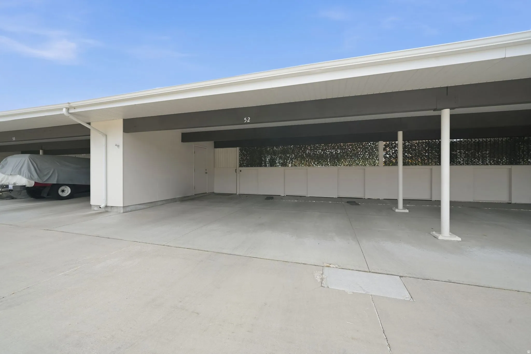Designated expansive 3 car carport offering covered parking, a dedicated storage unit, and direct private access to backyard
