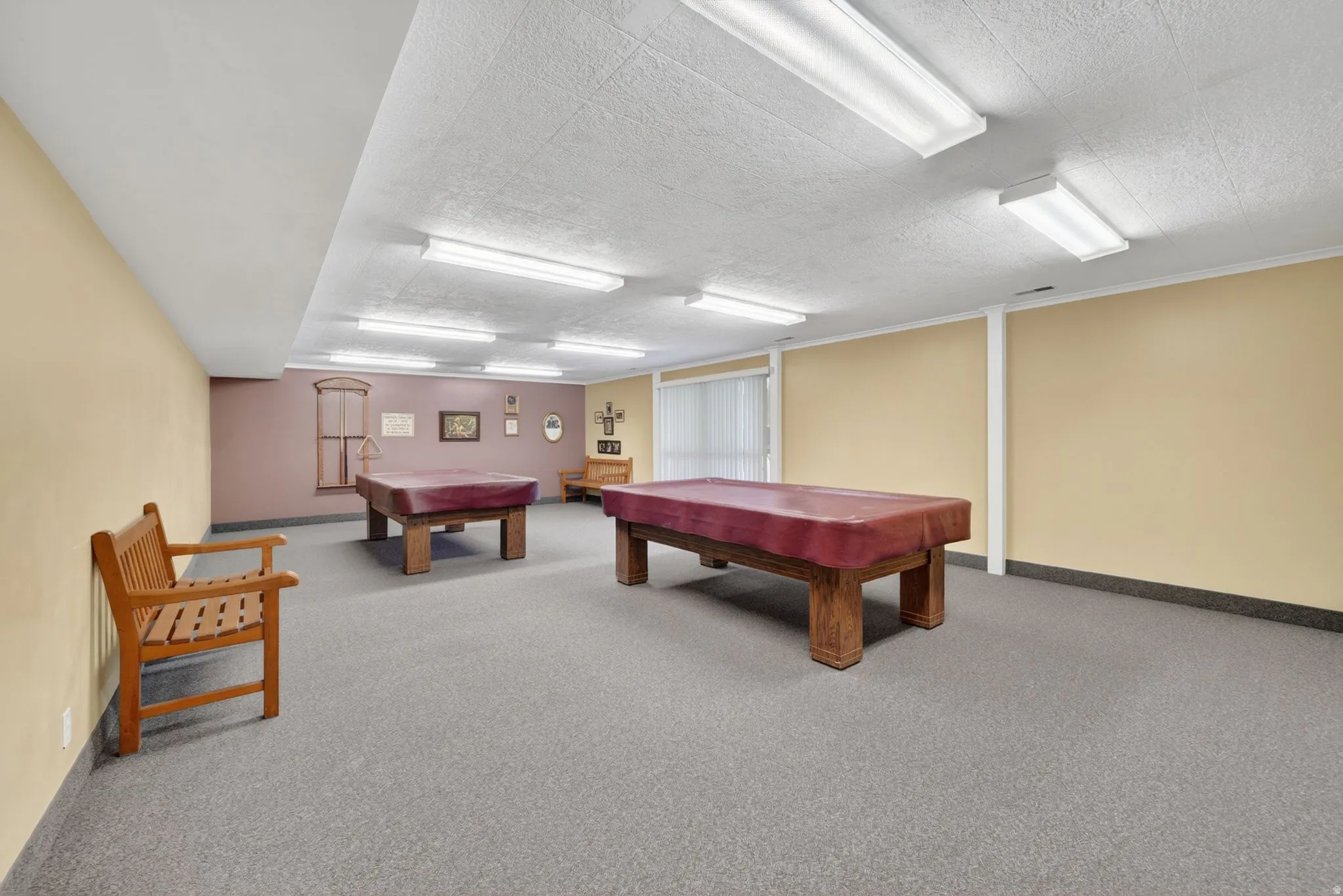 Club house billiards room with spacious room featuring neutral carpeting, two large pool tables, and track lighting