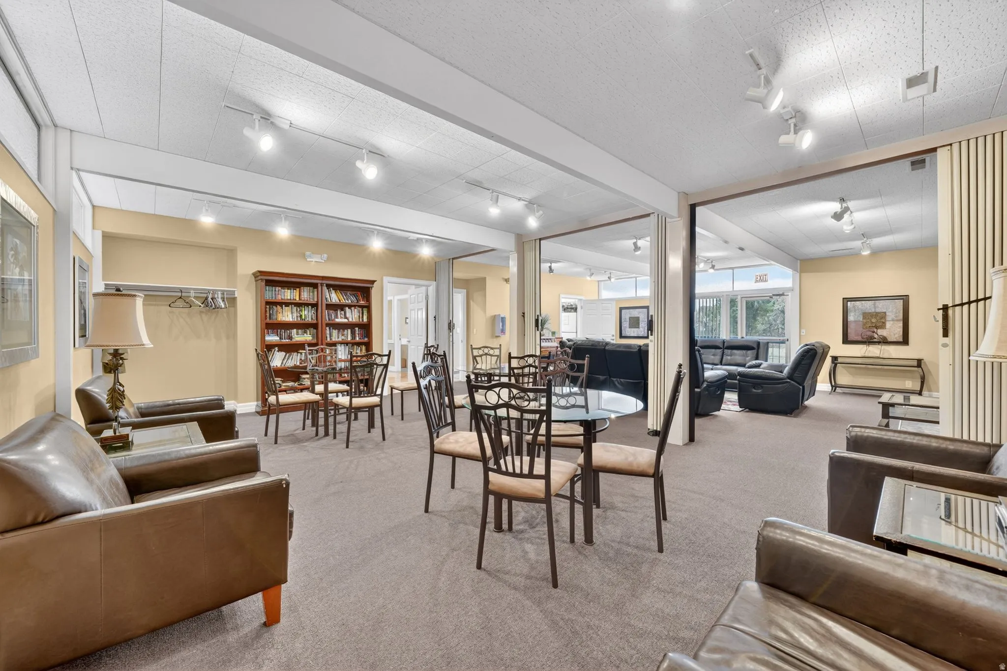 Clung house spacious hosting/ gathering area featuring neutral carpeting, recessed track lighting, and cream-colored walls
