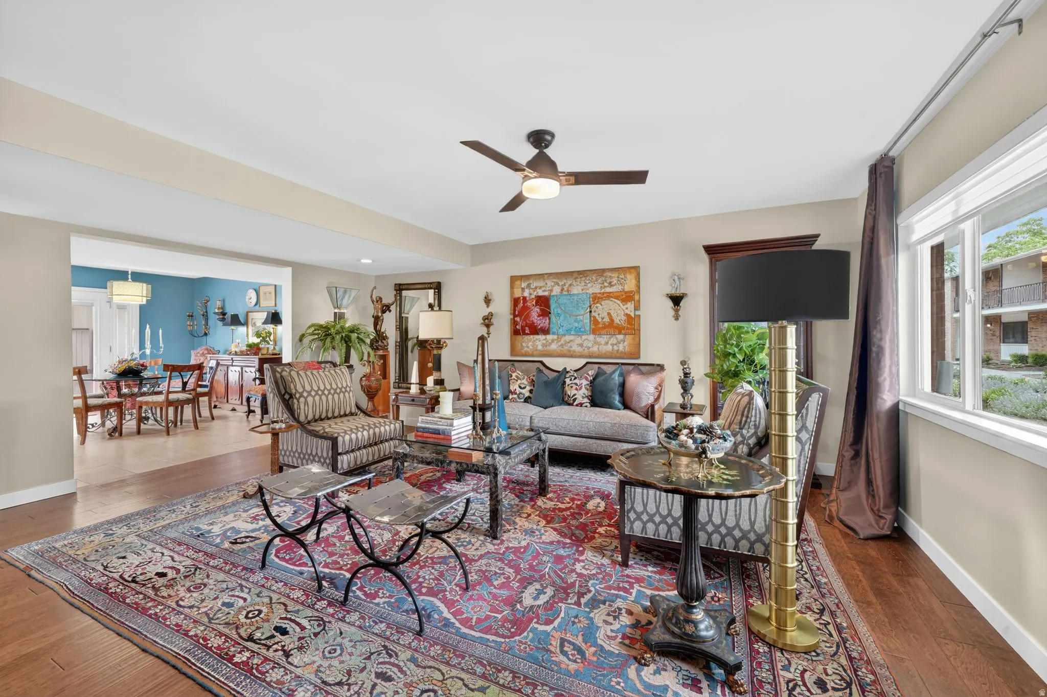 Spacious living area featuring engineered hardwood flooring, a ceiling fan with integrated lighting, and recess lighting throughout