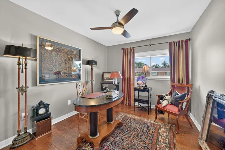 Bedroom/ office featuring a ceiling fan with integrated lighting, window with natural light, and neutral wall paint