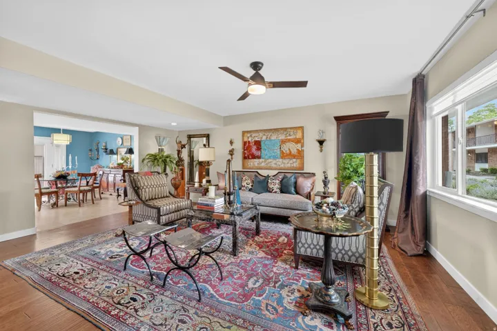 Spacious living area featuring engineered hardwood flooring, a ceiling fan with integrated lighting, and recess lighting throughout