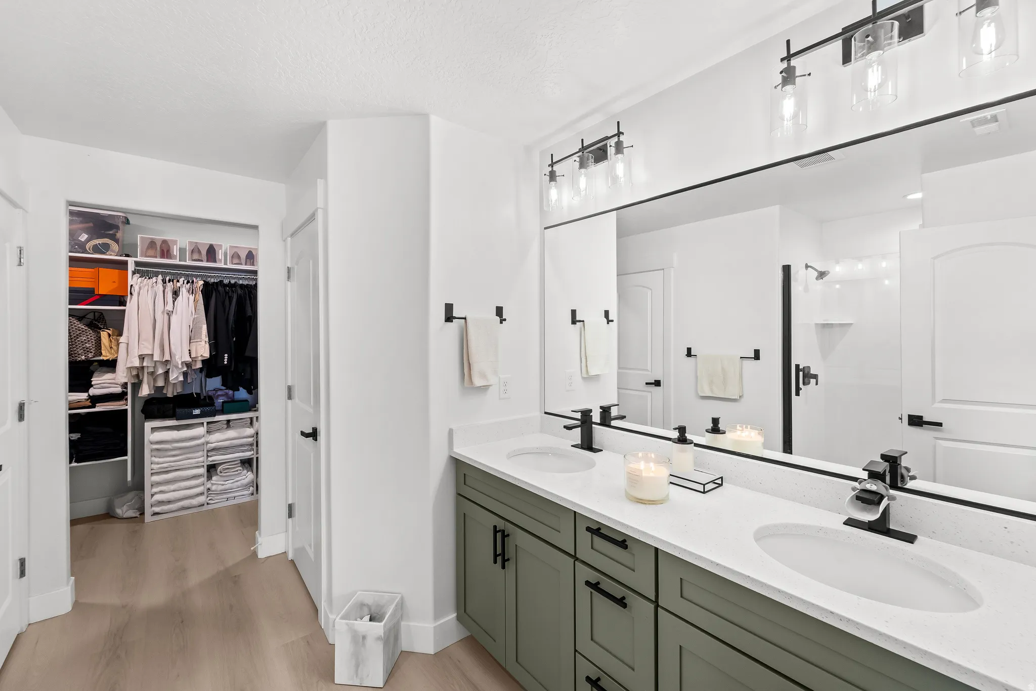 Bathroom vanity featuring dual undermount sinks, stone countertops, and matte black fixtures