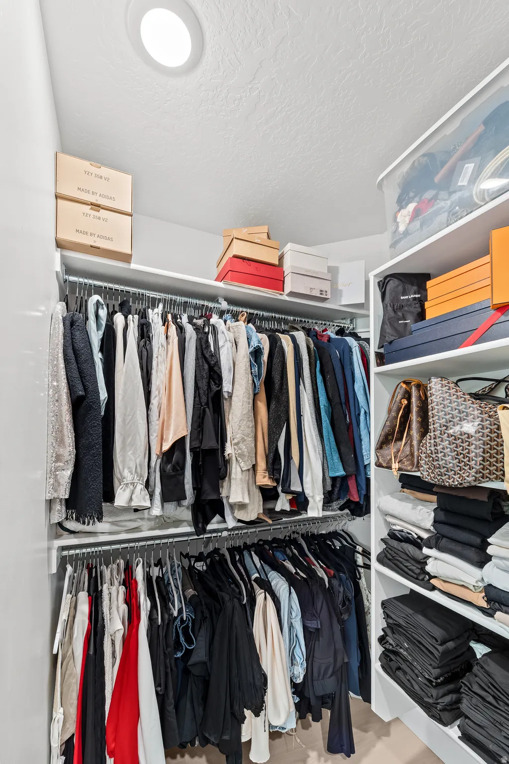 Custom closet system featuring white shelving and chrome hanging rods
