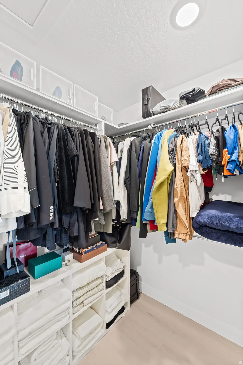 Walk-in closet with recessed lighting, built-in shelving, and hanging rods