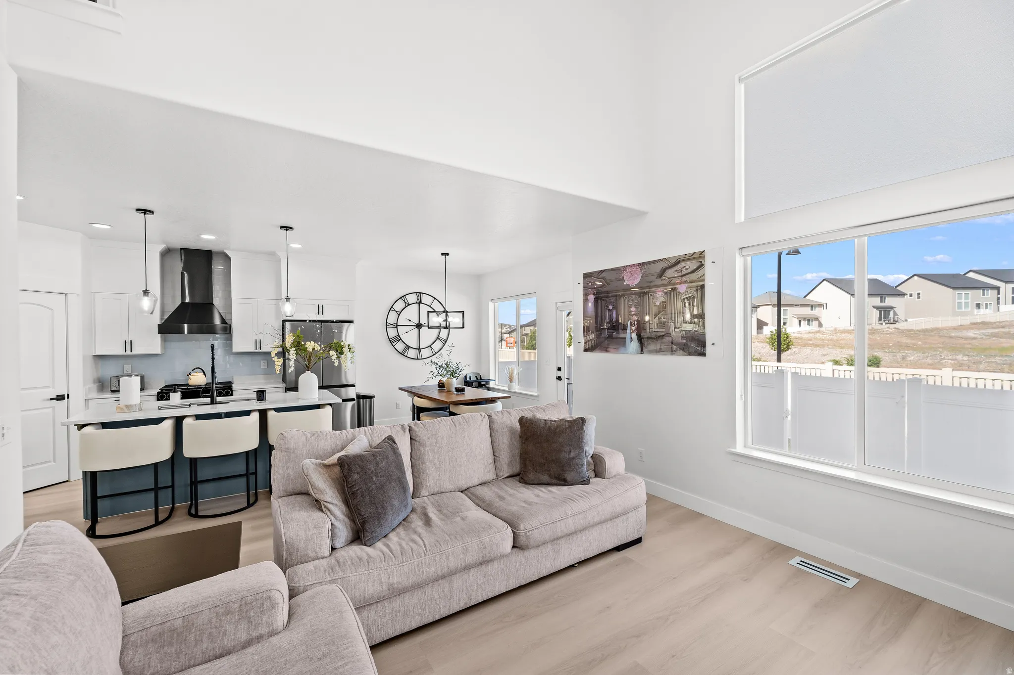 Vaulted ceilings illuminate an open concept living area featuring light wood-finish flooring