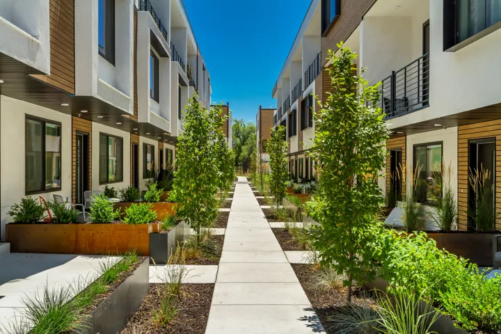 Modern townhome community featuring contemporary architectural design with white stucco and wood-finish siding