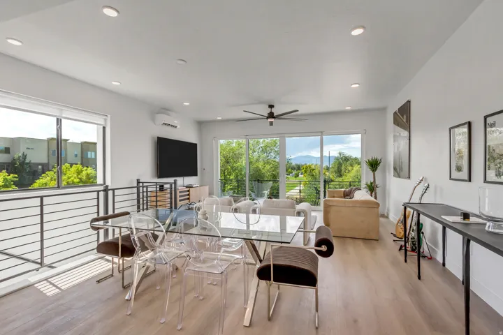 Open-concept living space featuring wood-finish flooring, recessed lighting, and a ceiling fan
