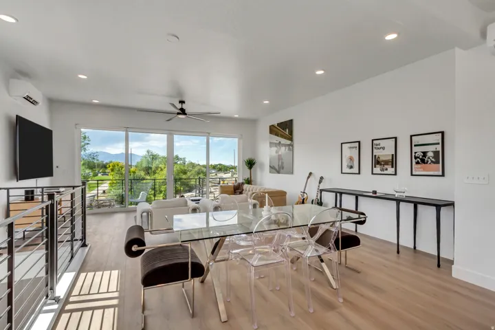 Open-concept living area with wood-finish flooring, a contemporary ceiling fan, and recessed lighting