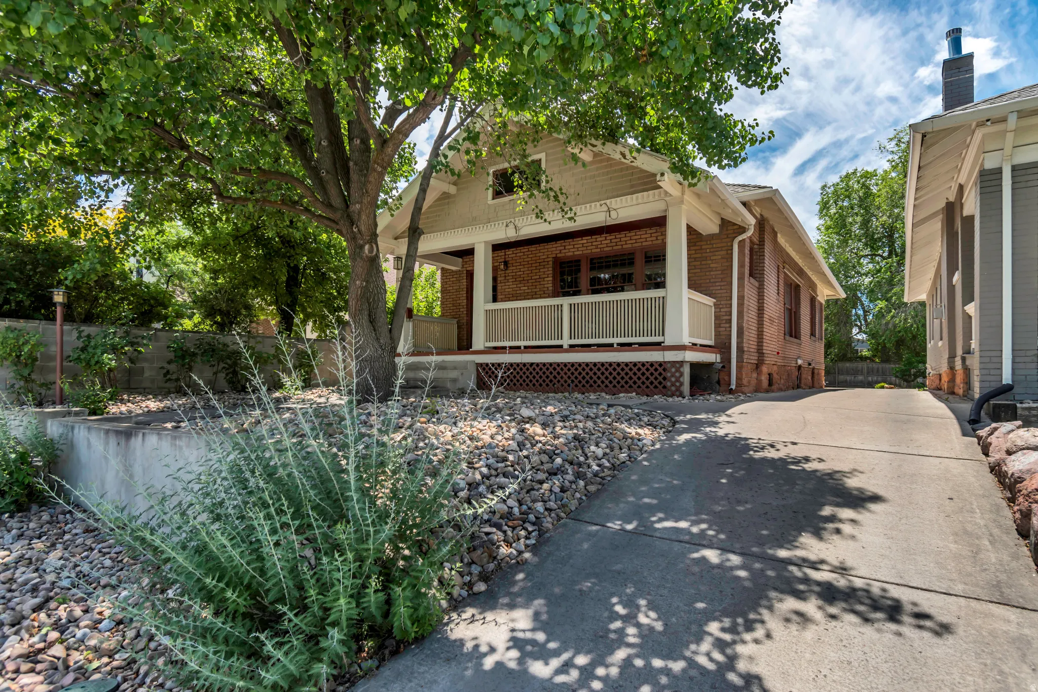 Brick exterior featuring a covered front porch with white railings and columns
